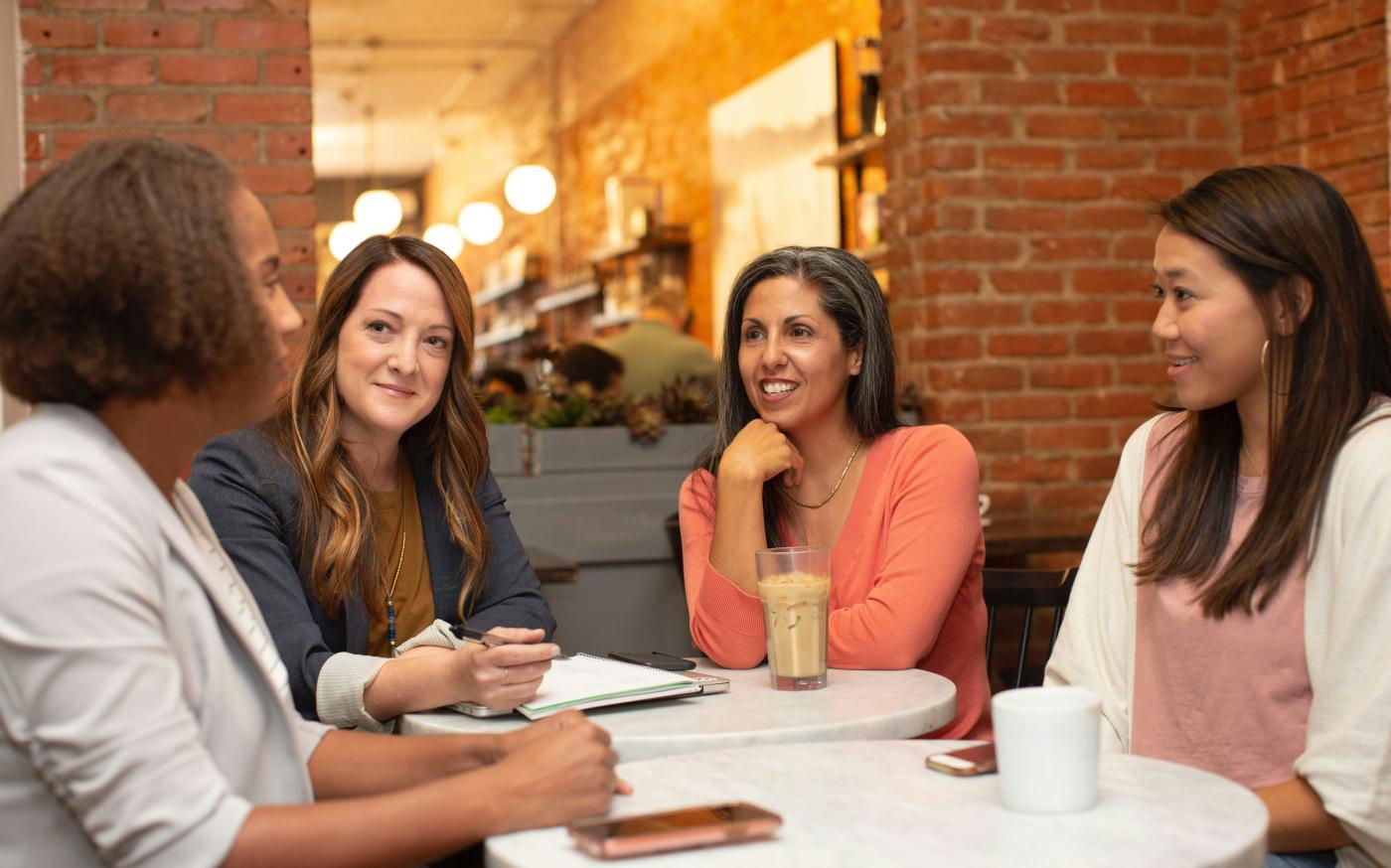 woman in black jacket sitting beside woman in white blazer by LinkedIn Sales Solutions courtesy of Unsplash.