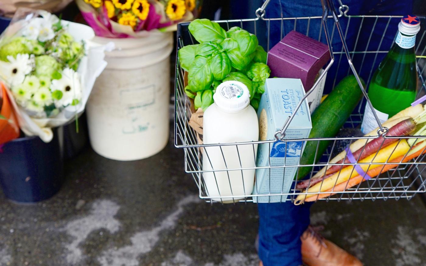 person in blue denim jeans and brown leather boots holding green plastic bag by Tara Clark courtesy of Unsplash.