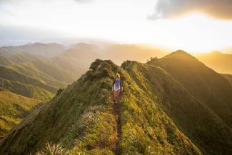 woman walking on pathway on top of hill at golden hour by Kalen Emsley courtesy of Unsplash.